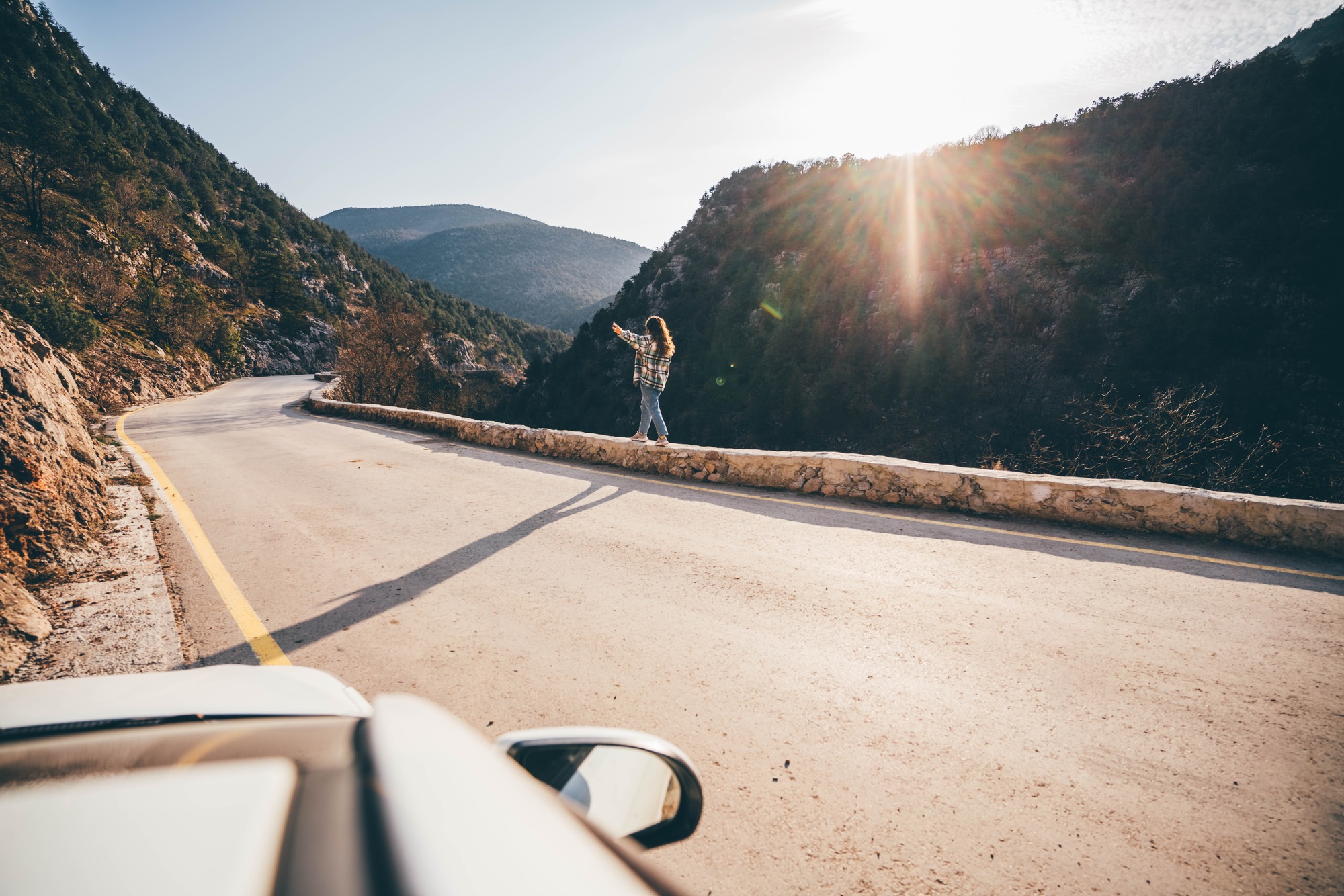 Woman on the road trip enjoying sunset.
